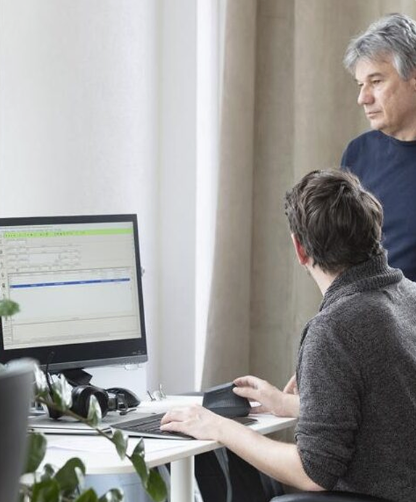 Zwei Mitarbeitende arbeiten gemeinsam am Bildschirm mit Adressdaten im Curion-System.